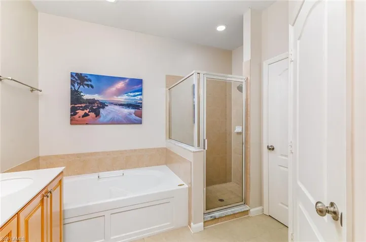 Mater Bathroom featuring tile flooring, vanity, plus walk in shower