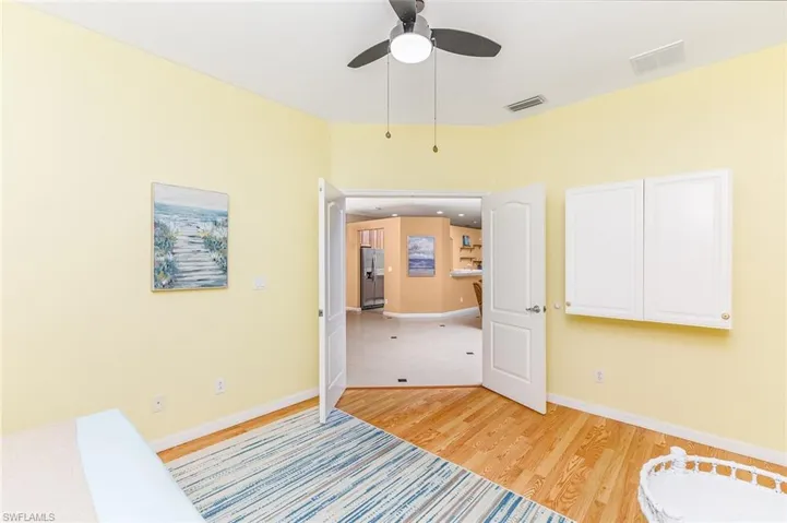 Den looking out into the home with ceiling fan,