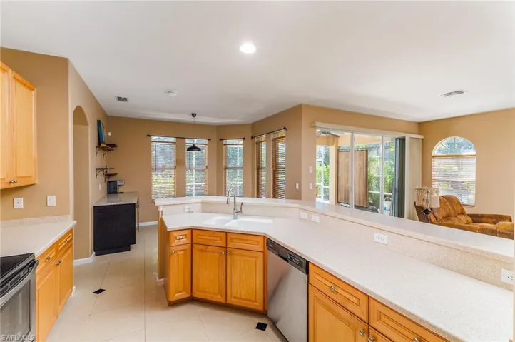 Kitchen with plenty of natural light, sink, dishwasher, and light tile floors