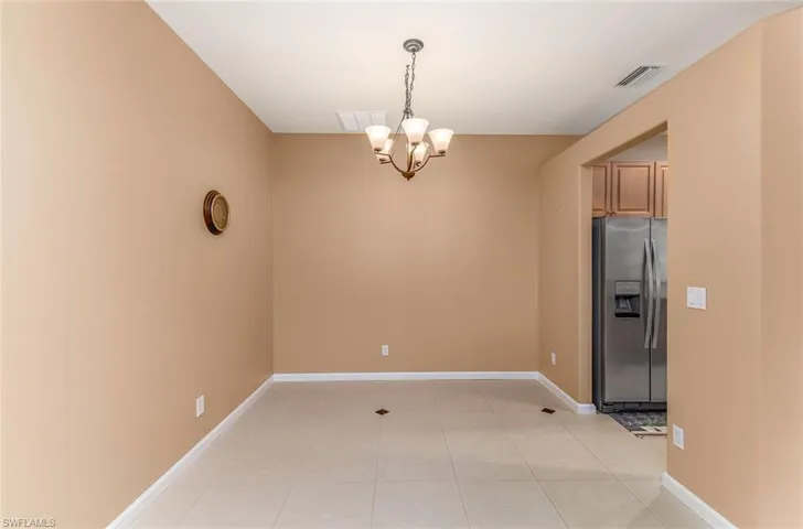 Dinning room with a chandelier and light tile floors