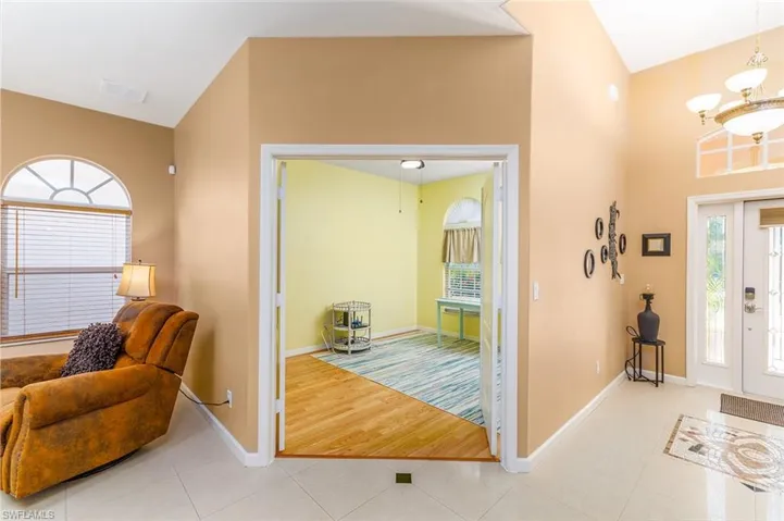 View looking into the den to right is Foyer featuring vaulted ceiling