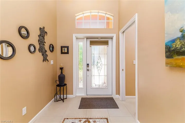 Tiled entrance foyer featuring a towering ceiling