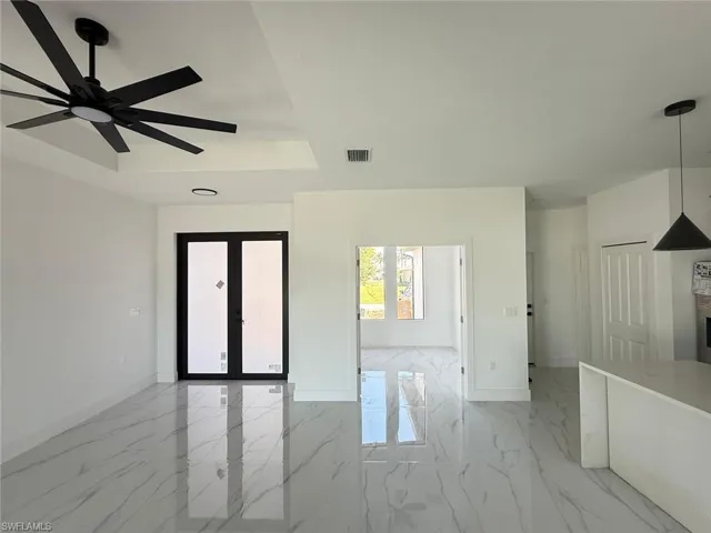 Spacious interior featuring marble-look tile flooring, a contemporary black ceiling fan, and recessed lighting