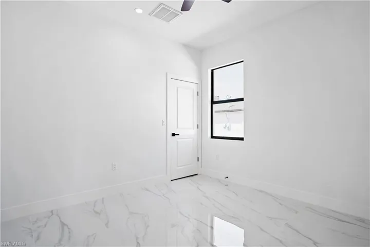 Bright room featuring large format tile flooring, a contemporary ceiling fan, and a black-framed window