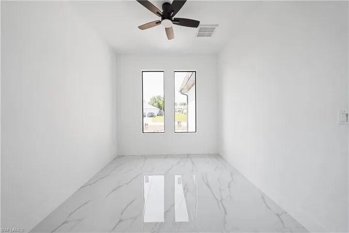 Room featuring white walls and large-format porcelain tile flooring