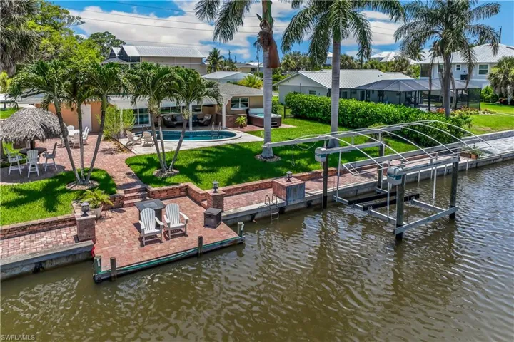 View of dock featuring a patio, a water view, and a yard