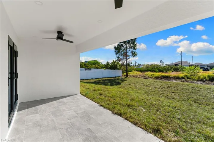 View of yard featuring ceiling fan and a patio