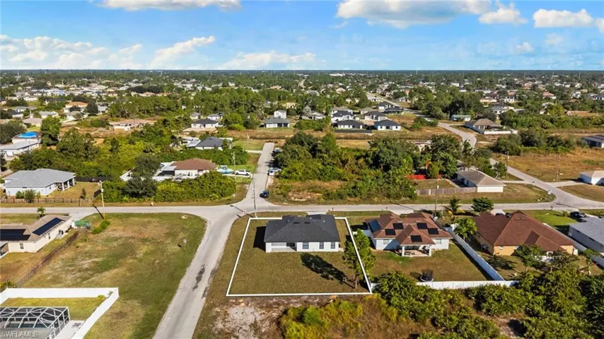 Aerial view of property and surrounding area with nearby suburban area