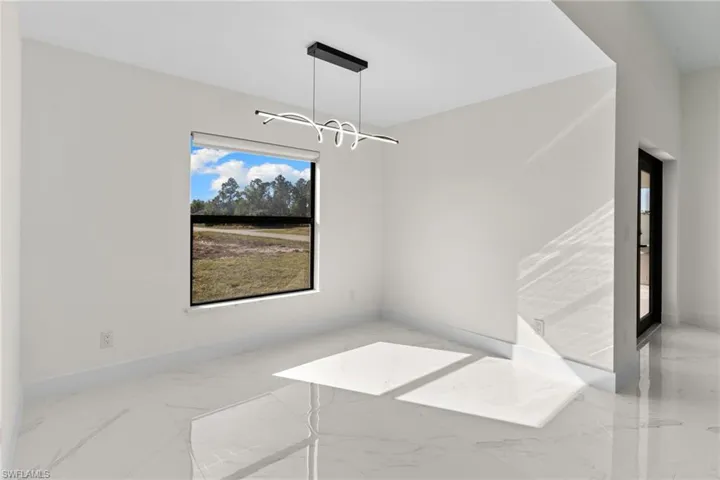 Empty room featuring light marble finish floors and baseboards