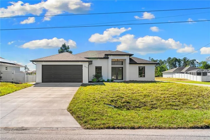Prairie-style house with stucco siding, concrete driveway, a garage, and a shingled roof