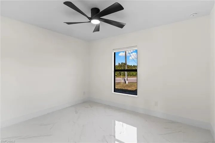 Unfurnished room with baseboards and light marble finish floors