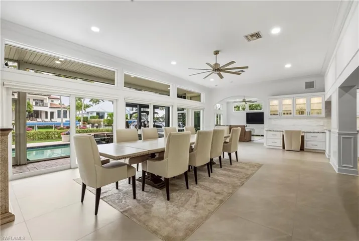 Dining room featuring healthy amount of natural light, ornamental molding, ceiling fan, and recessed lighting