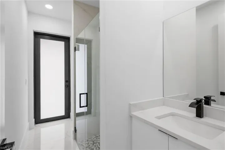 Bathroom featuring vanity and a shower with door