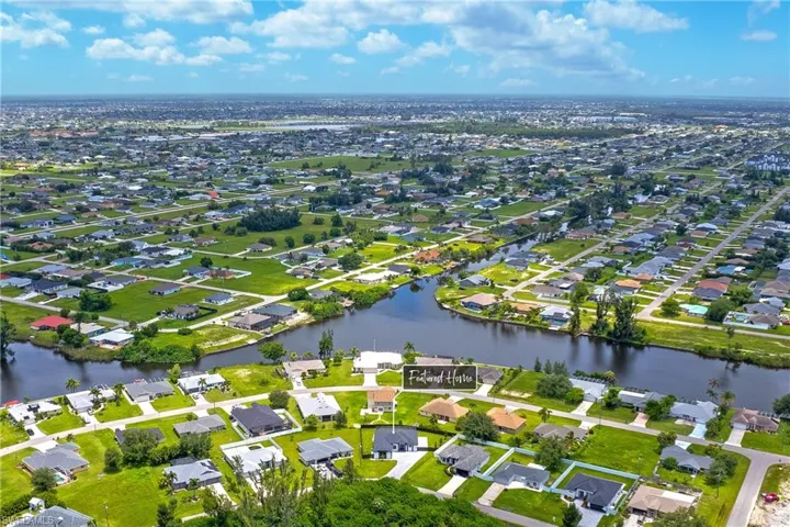 Birds eye view of property with a water view