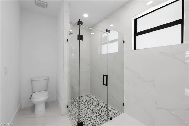 Bathroom with toilet and a shower with door