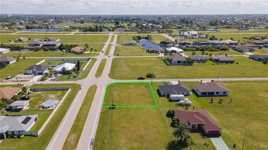 Aerial perspective of suburban area featuring property parcel outlined and a nearby body of water