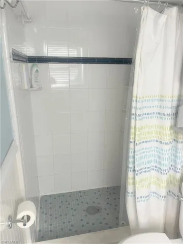 Bathroom featuring a shower stall and toilet