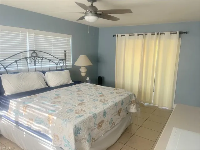 Bedroom with light tile patterned floors and a ceiling fan
