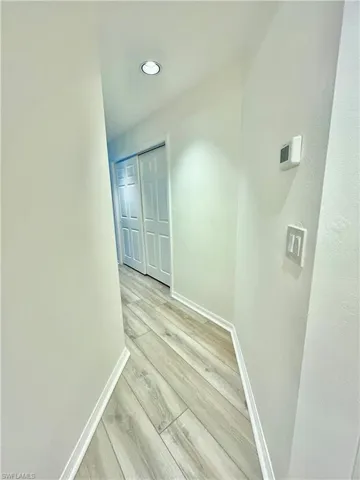 Hall with baseboards and light wood-style flooring