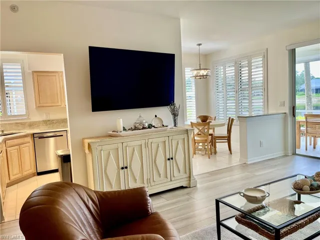 Living area with a chandelier, light wood-type flooring, and baseboards