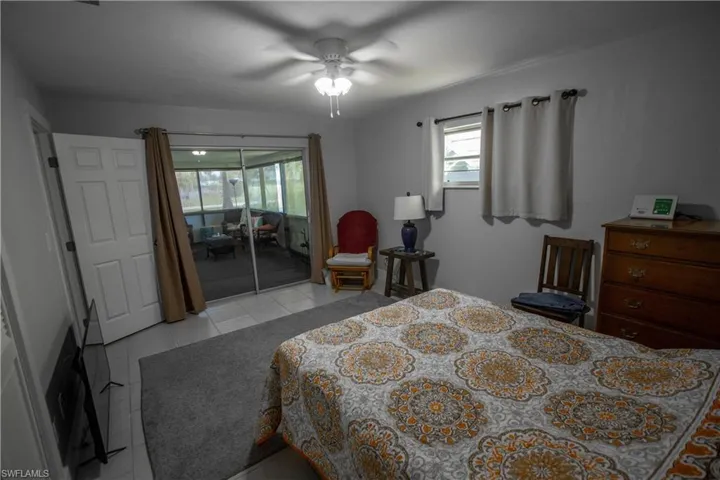 Tiled bedroom with access to outside and ceiling fan