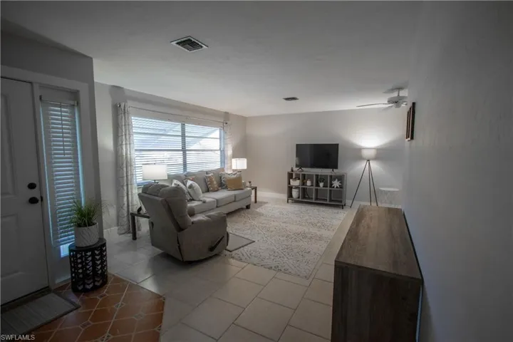 Living room featuring light tile patterned flooring and ceiling fan
