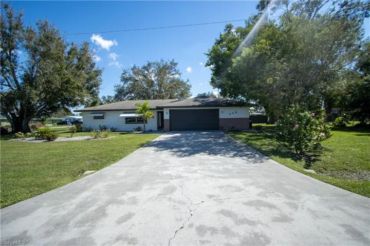 Ranch-style home with a garage and a front lawn