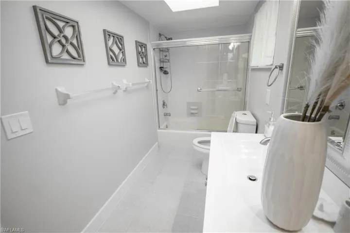 Full bathroom featuring tile patterned flooring, vanity, enclosed tub / shower combo, and toilet