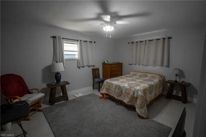 Bedroom with ceiling fan and light tile patterned floors