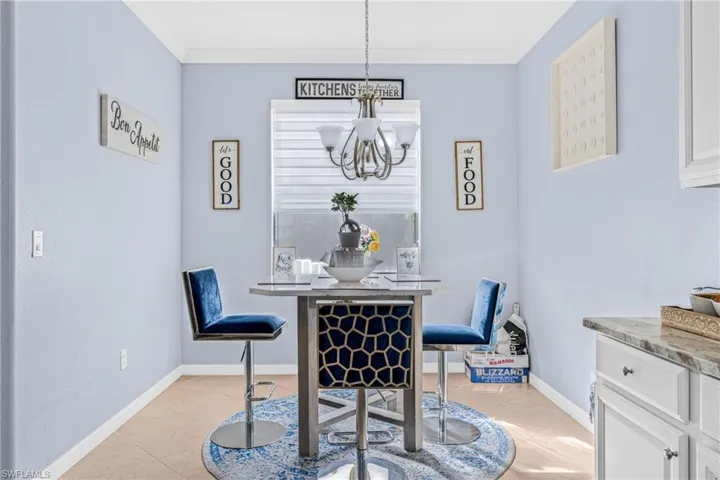 Dining area with crown molding, suspended lighting, and light tile patterned floors