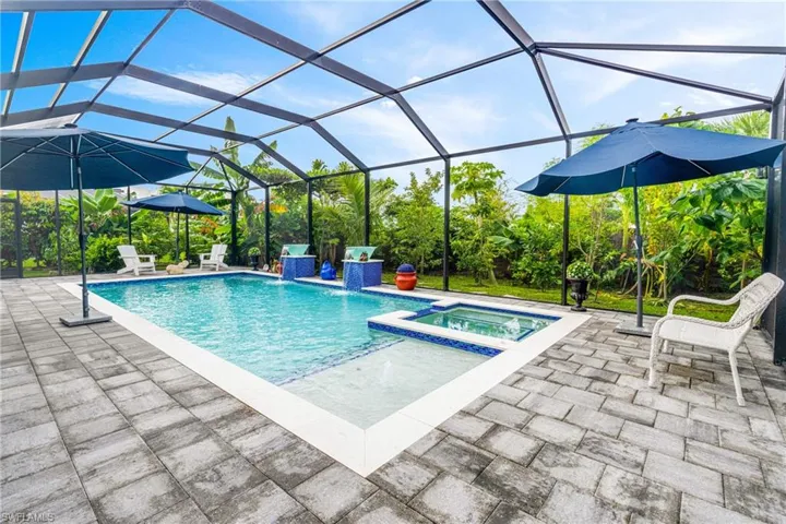 Relaxing pool / spa with glass enclosure, a sunroom, and a patio area