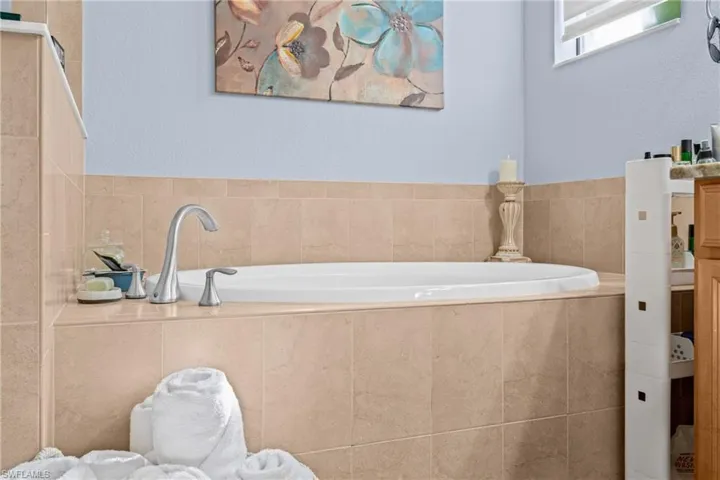 Full bath with a bath and a textured wall