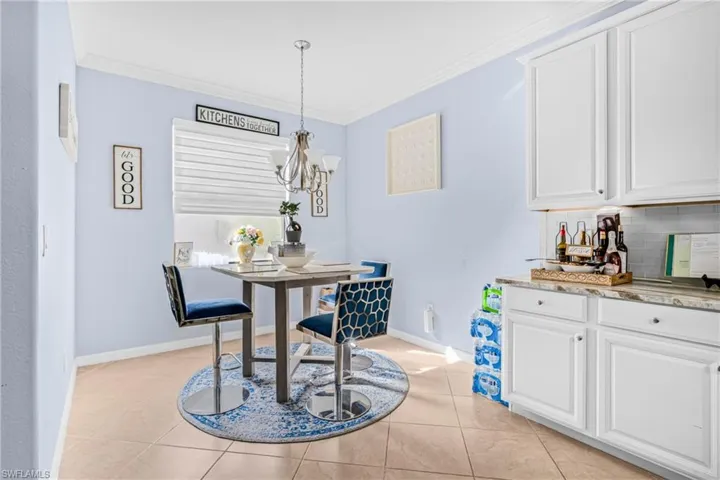 Dining area featuring ornamental molding, light tile patterned floors, and suspended lighting
