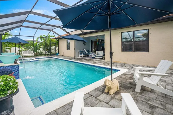 Integrated pool / hot tub featuring a patio area, a sunroom, and glass enclosure