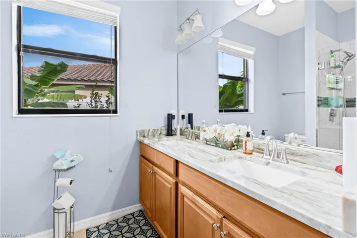 Full bath with a shower stall and double vanity