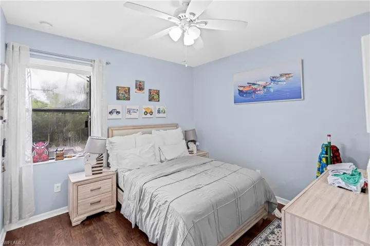 Bedroom with dark wood-type flooring and a ceiling fan