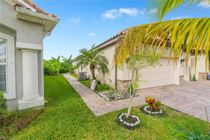 View of green lawn featuring driveway and an attached garage