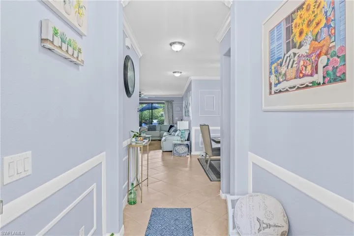 Hall featuring crown molding and light tile patterned floors