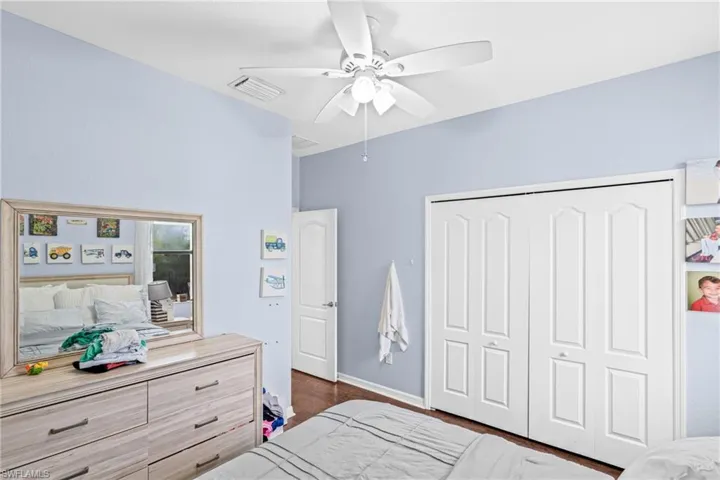 Bedroom featuring ceiling fan, a closet, and dark wood-style floors