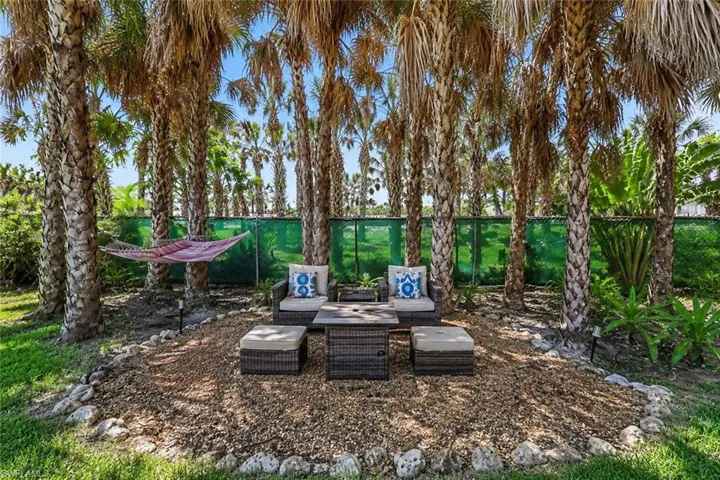 RETREAT AREA WITH OUTDOOR FURNISHING, PROPANE FIRE TABLE AND HAMMOCK.  PROPERTY BORDERS THE CATHOLIC CHURCH PROPERTY.