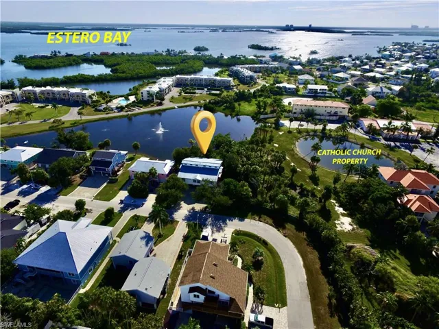 AERIAL VIEW OF LAKEFRONT COMMUNITY FEATURING MATURE LANDSCAPING, SERENE WATER FEATURES AND PROXIMITY TO ESTERO BAY