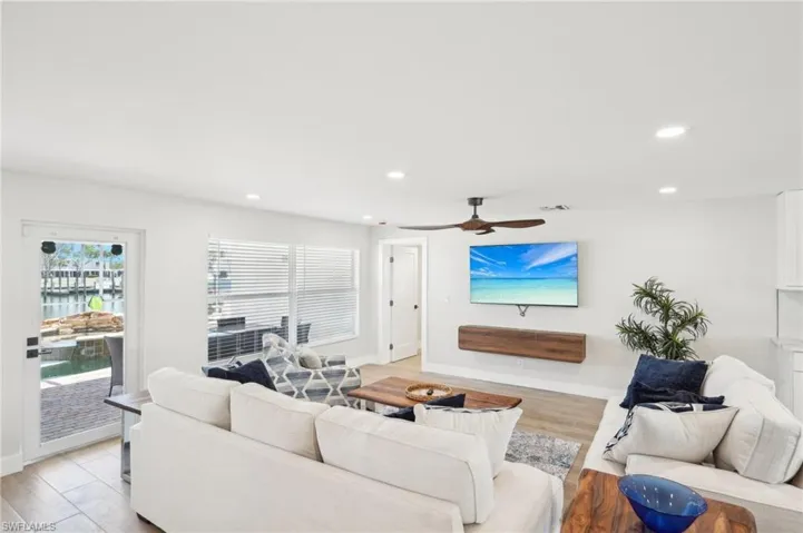 Living area with recessed lighting, baseboards, ceiling fan, and light wood finished floors