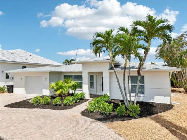 Single story home with decorative driveway, an attached garage, and stucco siding