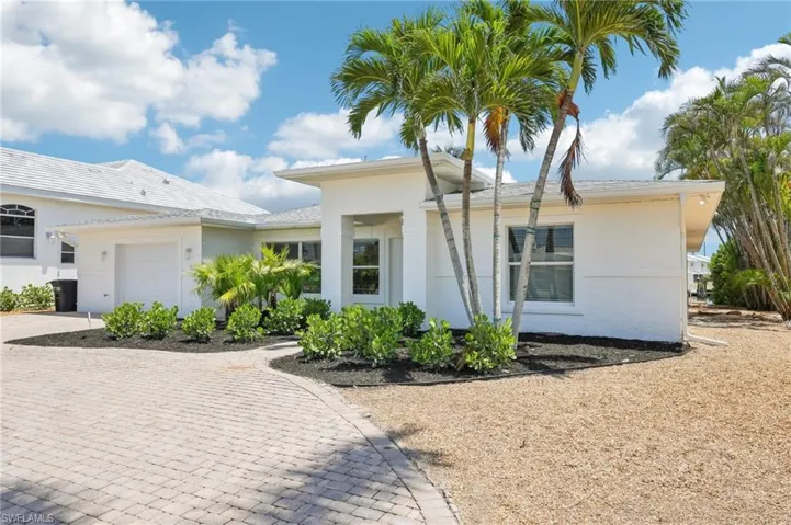 View of front of house featuring decorative driveway, a garage, and stucco siding