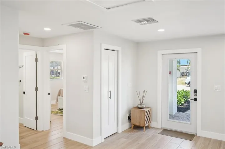 Entrance foyer with healthy amount of natural light, light wood-type flooring, baseboards, and recessed lighting