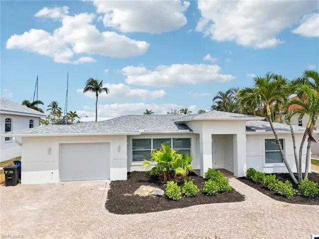 Ranch-style home with a garage, decorative driveway, and stucco siding