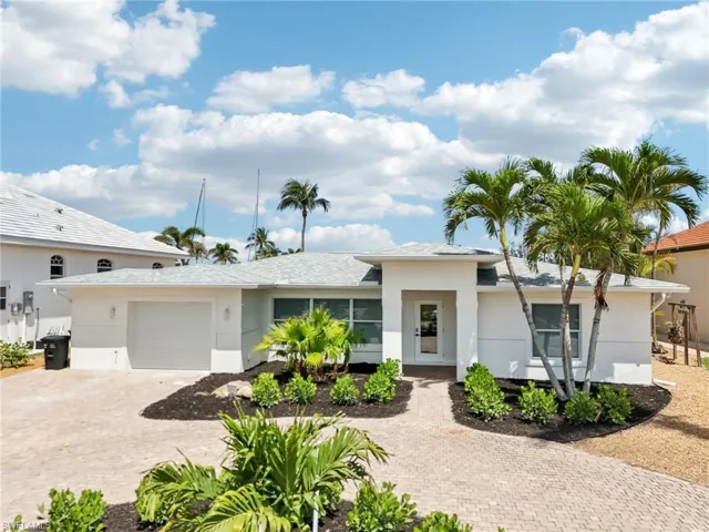 View of front of home featuring decorative driveway, an attached garage, and stucco siding