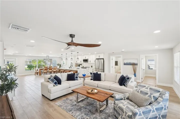 Living room with baseboards, plenty of natural light, light wood finished floors, and recessed lighting