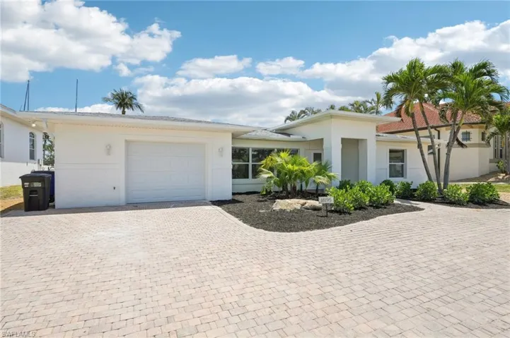 View of front of home featuring an attached garage, decorative driveway, and stucco siding