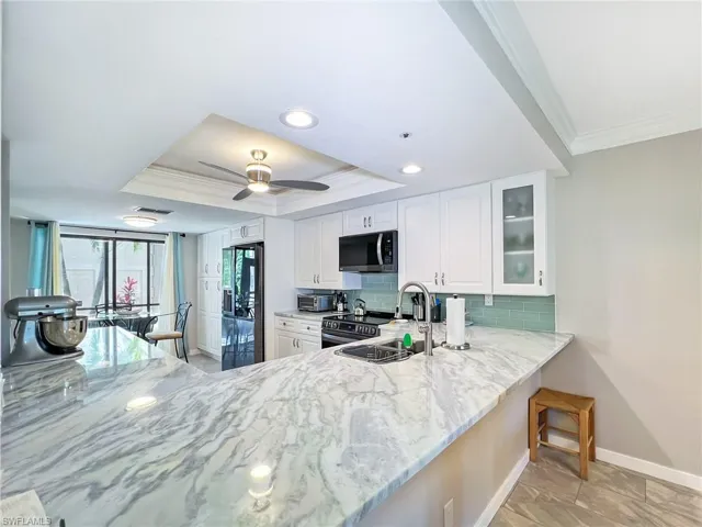 Beautiful granite kitchen looking out onto front lanai.
